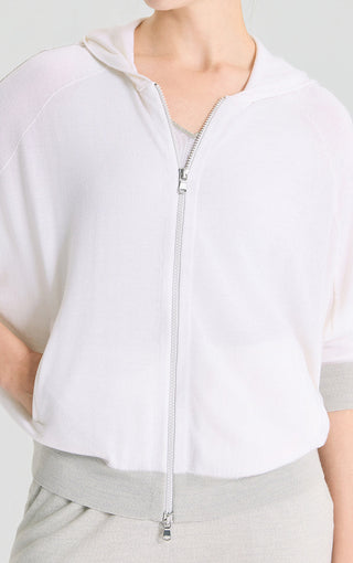 Close-up of white hooded knit cardigan zipper front with hood seam and drawcord