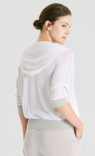 Back view of white hooded knit cardigan with short sleeves and subtle seam details