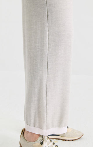 Light gray knit pants close-up showing vertical seam and wide straight leg opening