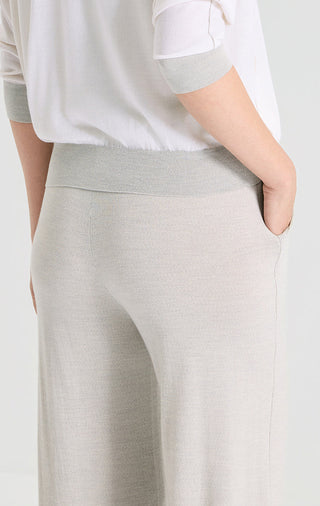 Light gray wide-leg knit pants close-up at hip and side seam, elastic waist