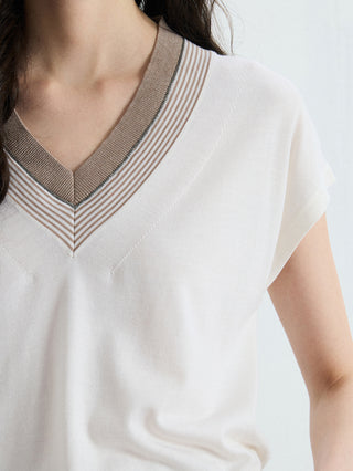Close-up of ivory V-neck knit collar with brown and striped contrast trim