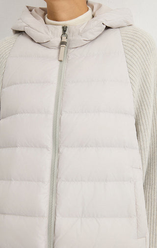 Light grey hooded puffer vest close-up of full-zip front and quilted stitch lines