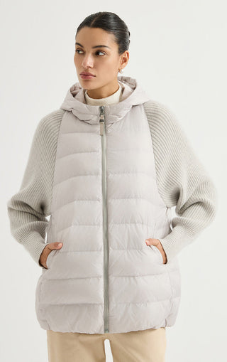 Light grey hooded puffer vest with ribbed knit sleeves, full-zip front, side pockets