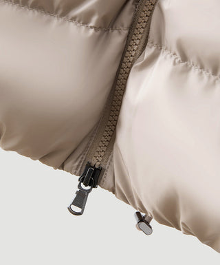 Dark hooded puffer vest detail with zipper pull and toggle fasteners at hem