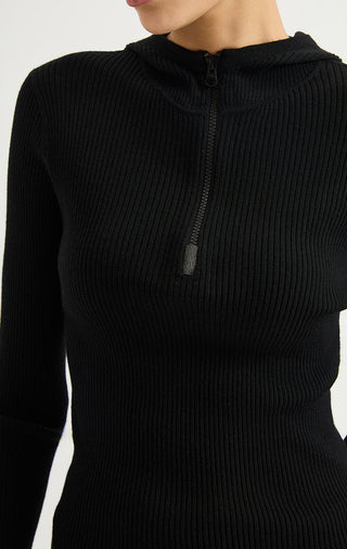 Black ribbed half-zip hooded sweater close-up with metal zipper pull