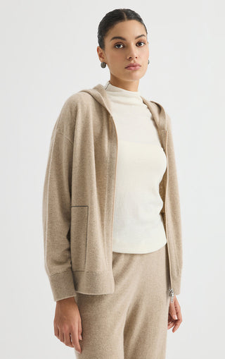 Camel cashmere zip-up hoodie layered over a top, hood and front zipper visible