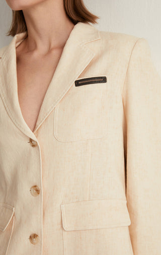 Apricot linen-cotton tailored jacket close-up of beaded pocket label on flap