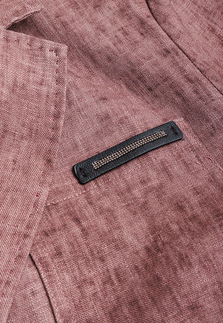 Rose linen-cotton fabric close-up with dark pocket label and beaded trim