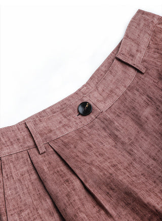 Reddish-mauve linen bermuda shorts close-up: waistband button and pleated front