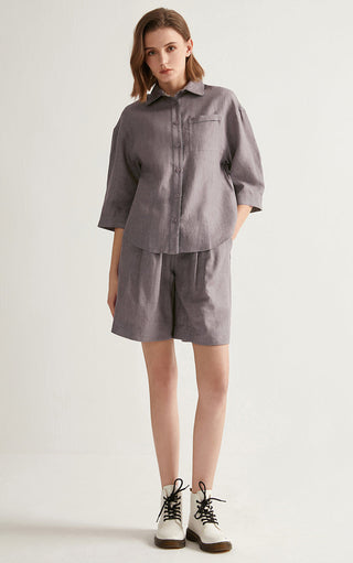 Gray linen elastic-waist shorts paired with a button-front shirt, front view.