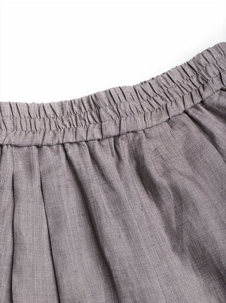 Top edge close-up of gray linen shorts showing elastic gathering and pleats.