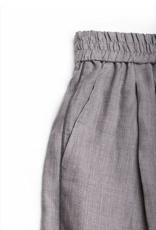 Close-up of gray linen elastic waist and stitched seam detail at side panel.