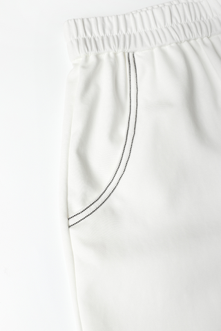 White shorts side waist close-up with black beaded drawstring and gathered elastic