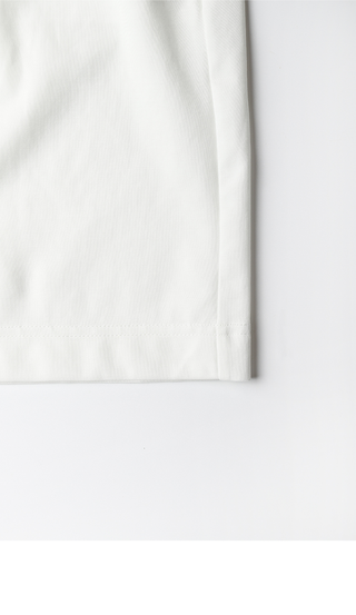 White shorts hem close-up with clean stitching and straight bottom edge