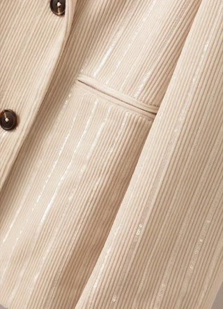 Beige pinstripe blazer fabric close-up with glittering vertical stripes and button placket