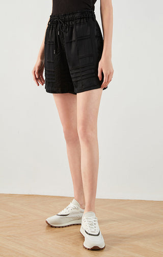 Black silk drawstring shorts, front view, elastic waistband and patch pockets