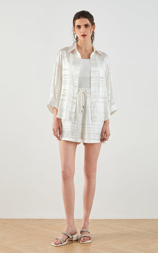 White silk textured drawstring shorts on model, elastic waist and drawcord