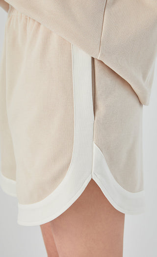 Apricot shorts side view with white trim and angled pocket opening detail