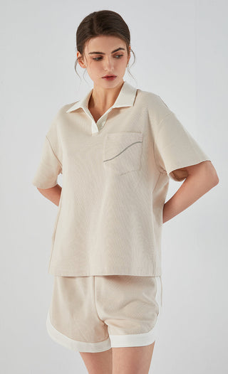 Apricot cotton-blend polo tee with short sleeves, collared neckline, and chest pocket
