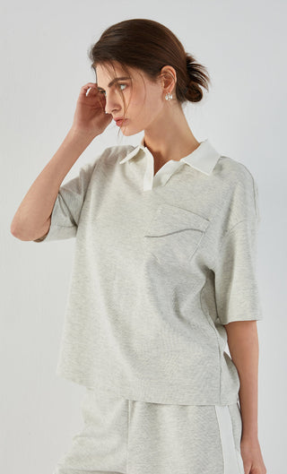Light gray polo tee with chest pocket, collared placket, and soft textured knit look