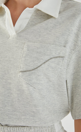 Light gray polo tee close-up of chest pocket with contrast piping and collar
