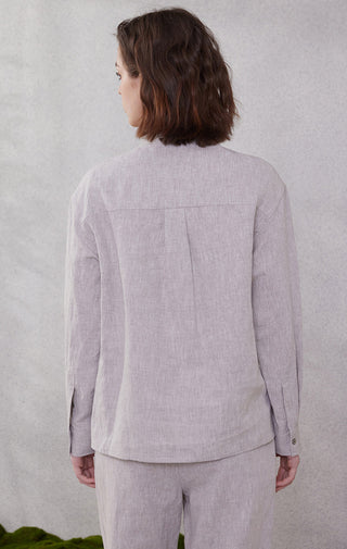 Back view of light purple linen tie-neck utility shirt with button detailing at cuffs