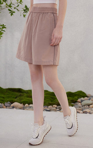 Rose-pink Tencel shorts with elastic waistband and vertical side trim along pocket.