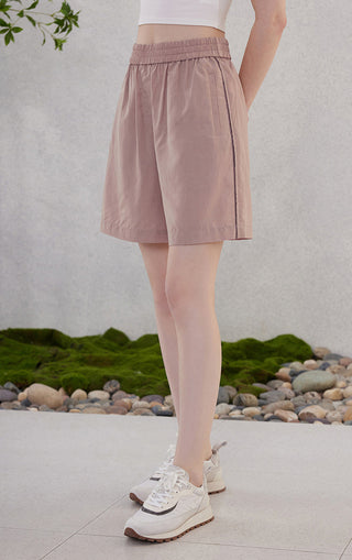 Rose-pink elastic waist shorts with side pleats and open side pockets, short hem.