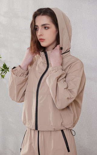 Camel hooded windbreaker with black zip, ribbed cuffs, and drawstring waist