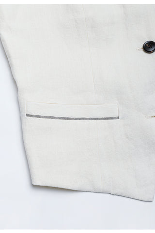White linen vest pocket flap detail with dark button near neckline