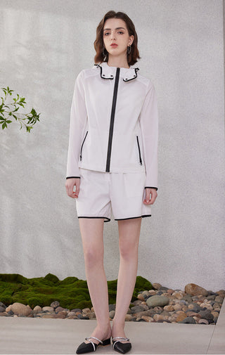 White elastic-waist shorts with black-trim hem, worn with coordinating outerwear