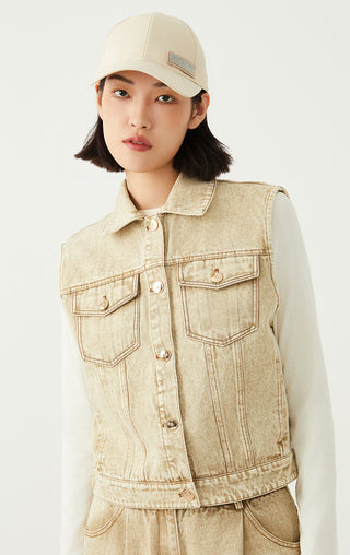 Light tan denim sleeveless jacket with flap pockets, gold-tone buttons, and collar