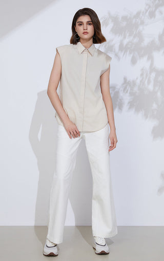Beige sleeveless button-up shirt worn with white trousers, pointed collar and placket