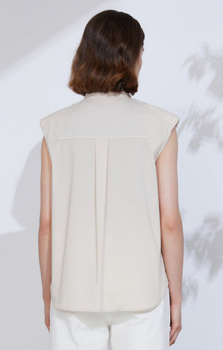 Back view of beige sleeveless button-up shirt with yoke seam and vertical pleat