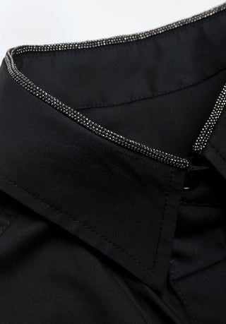 Close-up: black shirt collar with rhinestone-trim inner edge and button placket