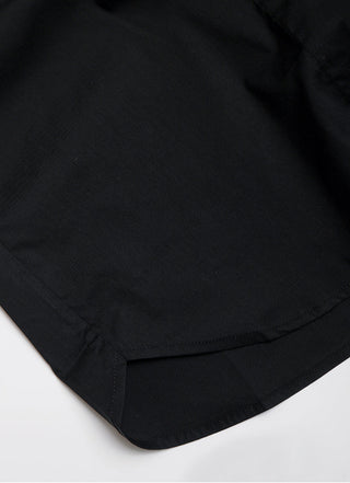 Black structured sleeveless shirt, close-up of hem and side seam stitching.