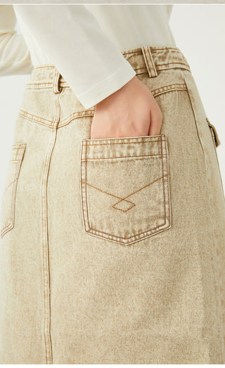 Khaki vintage-wash denim pocket detail with stitched triangular logo and flap closure