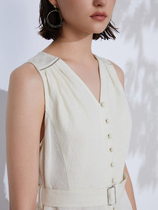 Close-up of white linen V-neck dress with button placket and waist belt buckle