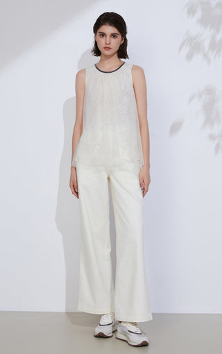 Ivory sleeveless top with dark beaded neckline, loose fit, and floral embroidery