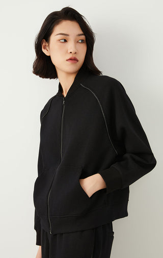 Black zip-up jacket with long sleeves, diagonal seam piping, and front patch pocket.