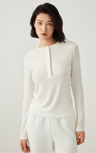 White henley long-sleeve top with 3-button placket and smooth fitted finish.