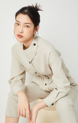Beige belted jacket detail with flap buttons and side pockets, long sleeves