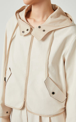 Beige hooded short jacket close-up with snap collar and side patch pocket