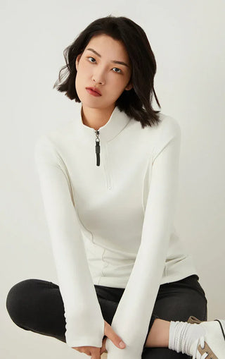 White half-zip knit top with high collar and beaded zipper pull, front close view