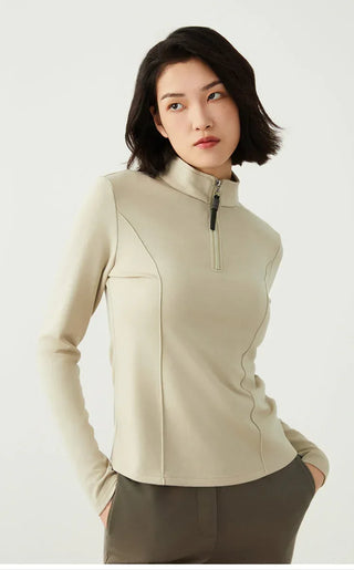 Sage green half-zip knit top with high collar and beaded zipper pull, front torso view