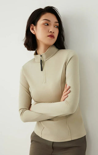Sage green half-zip knit top with beaded zipper pull and long sleeves, side stance