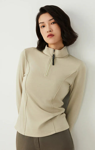 Sage green half-zip knit top with high neck and beaded zipper pull, angled front view