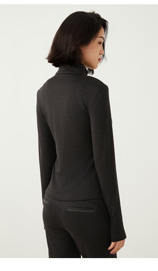 Back view of dark gray knit half-zip top with stand collar and long sleeves