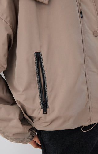 Beige puffer jacket chest pocket with vertical zipper detail