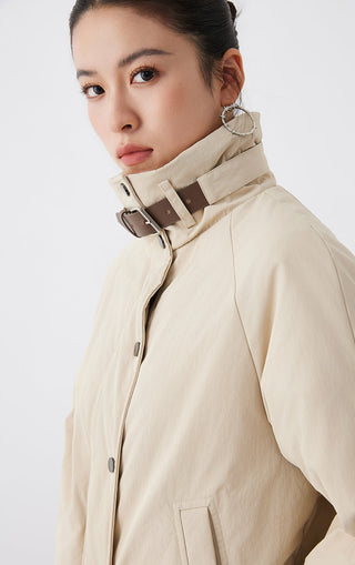 Apricot jacket close-up: stand collar with leather strap detail and button placket
